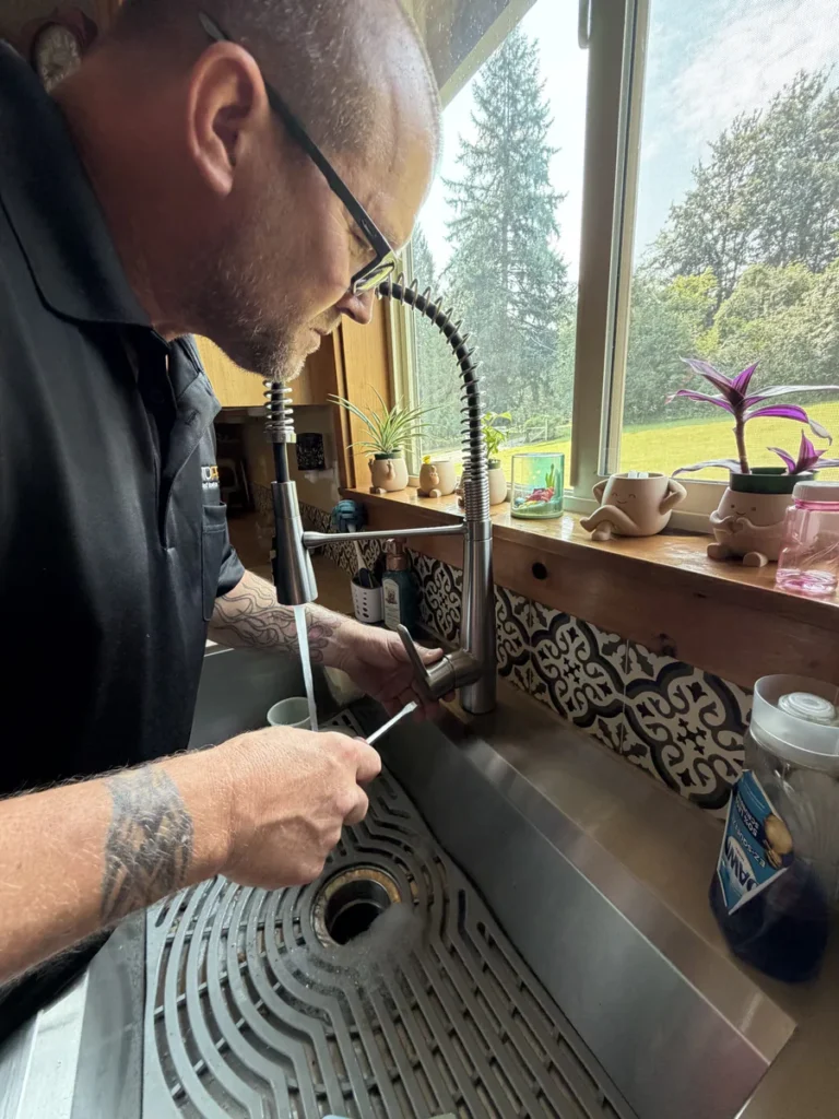 Plumber fixing the kitchen sink tap