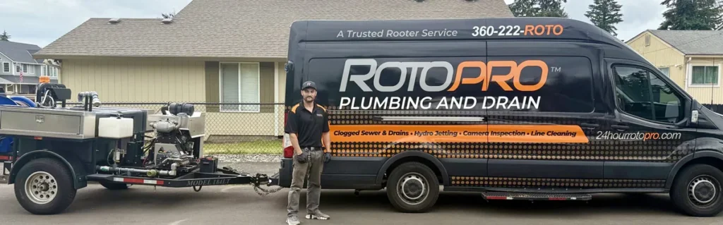 Roto Pro staff member standing in front of the company van and trailer