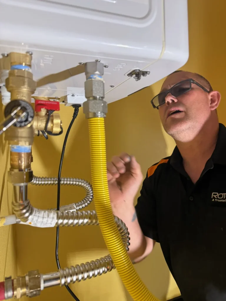 Plumber looking at a device mounted with pipes