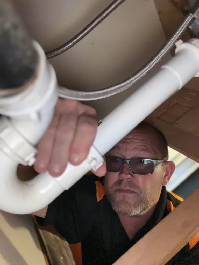 Plumber looking at pipes